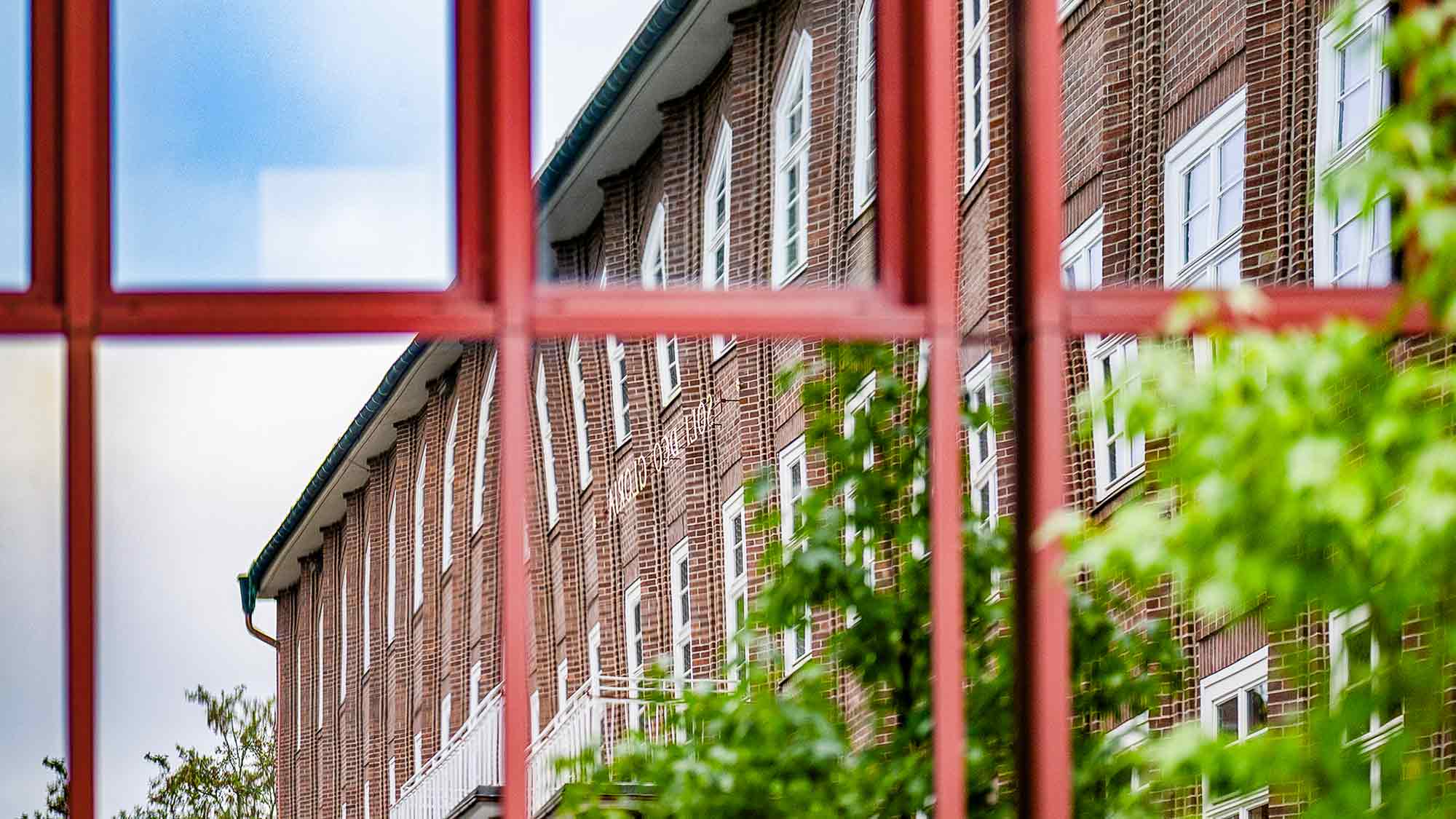 NOW Commons: Evangelisch Stiftisches Gymnasium (ESG) Gütersloh, soli deo gloria, Spiegelung in der Fassade der Mediothek