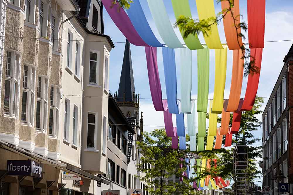 Installation der ISG Mittlere Berliner Straße sorgt für bunte Gestaltung – Regenbogenhimmel aus Stoff über der Mittleren Berliner Straße in Gütersloh Installation der ISG Mittlere Berliner Straße sorgt für bunte Gestaltung – Regenbogenhimmel aus Stoff über der Mittleren Berliner Straße in Gütersloh